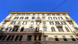 Ein mehrstöckiges Gebäude im klassischen Stil, mit aufwendigen Balkonen und großen Fenstern.