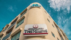Un letrero de hotel con el nombre 'Hotel Tres Milagros' y un logotipo encima.