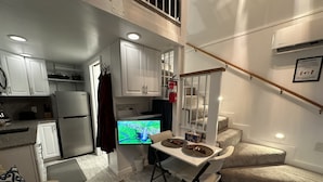 A compact living space with a kitchenette, dining area, and a staircase. - WATER FRONT- Cozy Country Home SPA, Pristine Lawns, wildlife & trails to Explore (Spokane)