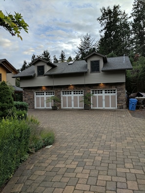 Ein zweistöckiges Haus mit einer Steinauffahrt und einer Garage mit weißen Türen.