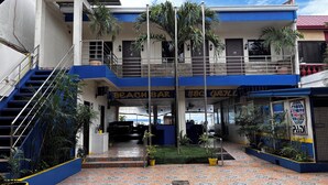 A two-story building with a blue and white exterior, a covered outdoor seating area, and a staircase leading to an upper level. - Mango's Beachfront Resort (Olongapo)