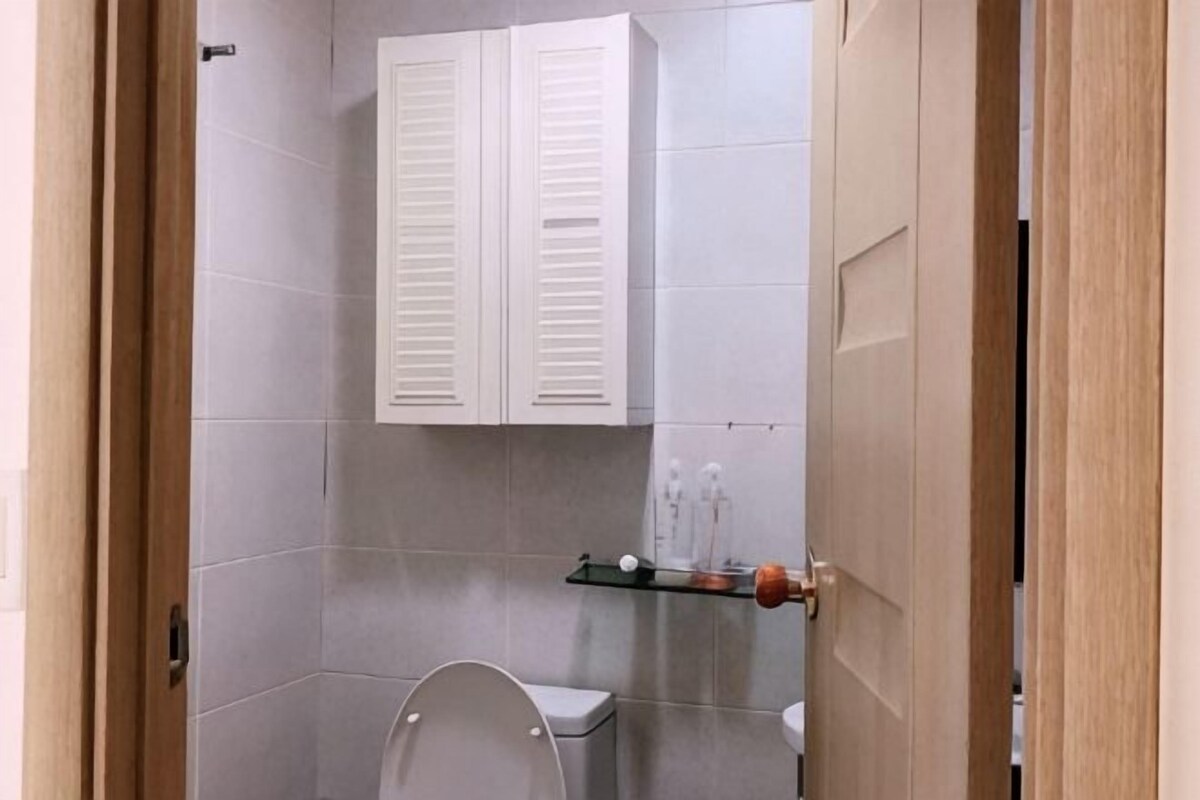 A bathroom with a toilet, a sink, and a cabinet above the mirror.
