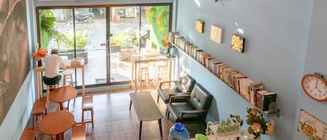 A cafe with wooden tables and benches, a counter with a water dispenser, and a view of the street outside.
