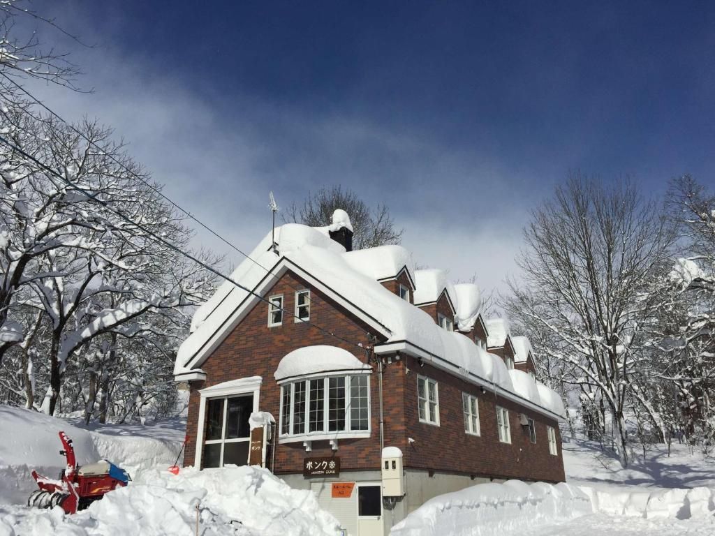 A snow-covered building with a brick exterior and a large window.