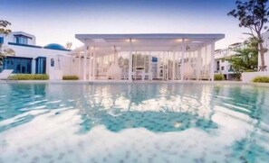 A modern pool area with a covered seating area and a clear view of the pool. - A2E Villa3 : The Crest Santora Hua Hin (Hua Hin)