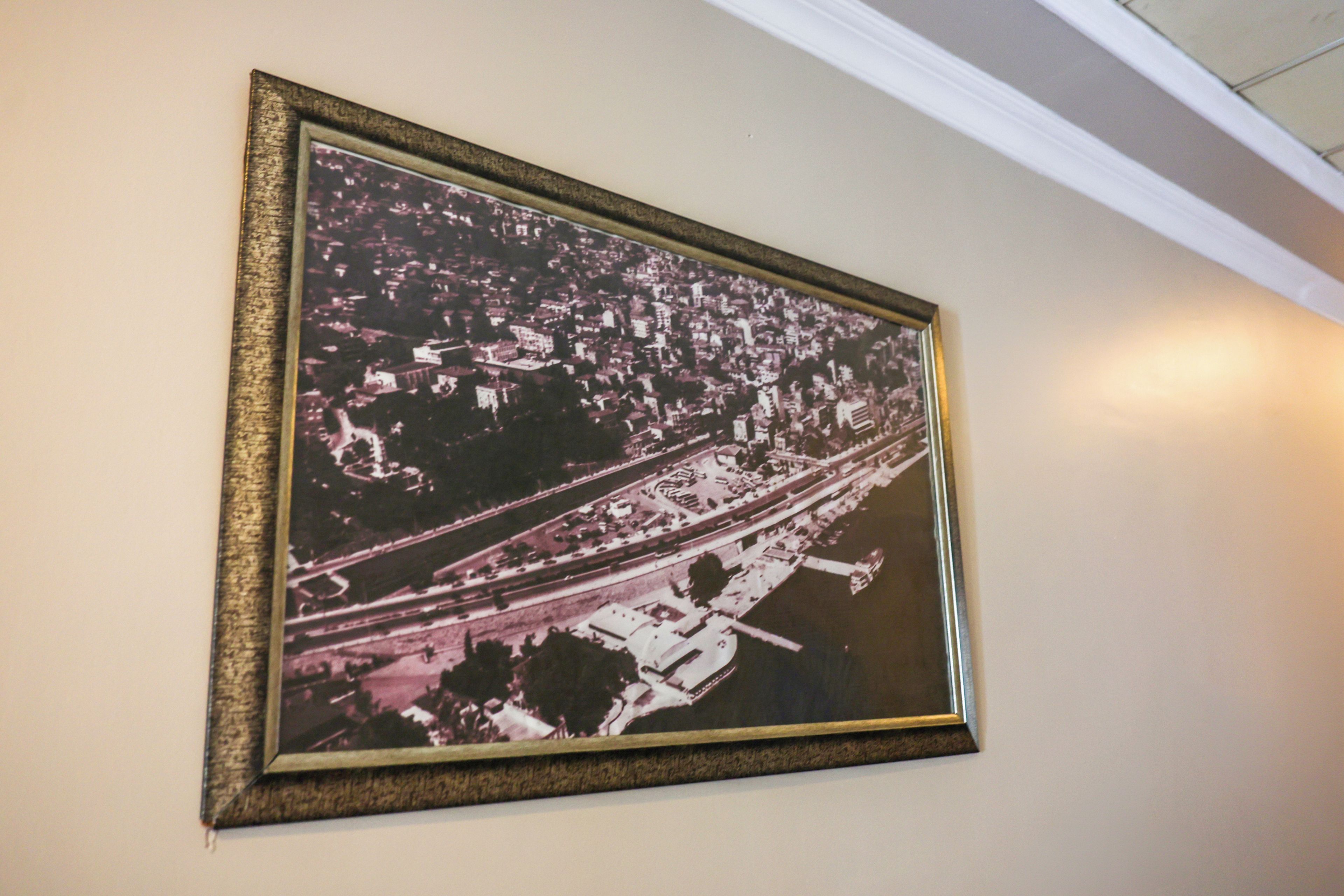 A framed aerial photograph of a cityscape with roads and buildings.