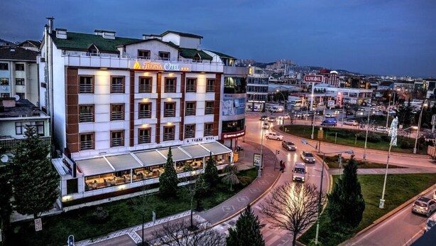 A hotel with a modern facade, multiple floors, and a restaurant on the ground level.