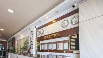 A reception area with a reception desk, clocks, and framed certificates on the wall.