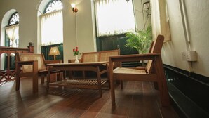 A room with wooden furniture, a table, chairs, and a potted plant. - 501 Merchant Bed & Breakfast - Hostel (Yangon)