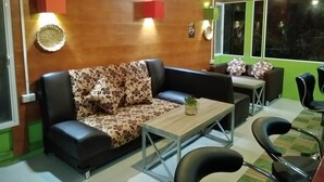 A modern living room with a sofa, a coffee table, and a dining area with chairs. - Peace Pool Resort (Khun Han)