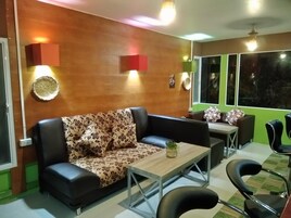 Uma sala de estar moderna com um sofá, uma mesa de centro e uma área de jantar com cadeiras.