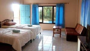 A hotel room with two beds, a small table, a brown leather sofa, and a TV. - Peace Pool Resort (Khun Han)