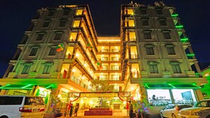 A multi-story hotel with a central courtyard, balconies, and a well-lit entrance. - Nyaung Shwe City Hotel (Nyaungshwe)