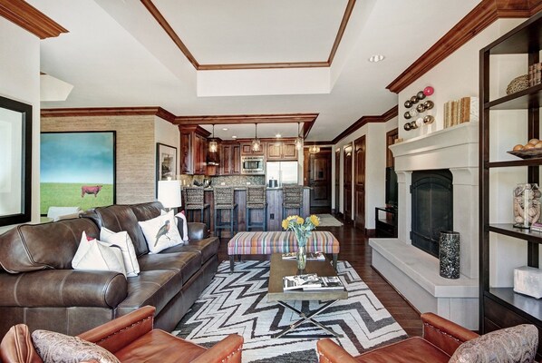 A spacious living room with a leather sofa, a coffee table, and a fireplace. - 2BR Residence at the Ritz-Carlton with Valley View by RedAwning - Save 20% on 7+ Nights! (Vail)