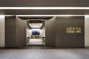 Une entrée moderne pour le spa Areca Yarey, avec une façade en verre, un espace d’accueil et une piscine visible.