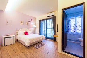 A bedroom with a bed, bedside table, and a view of the bathroom through an open door. - Ting Shuan B.B Hostel (Suao)