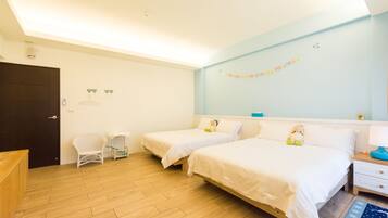 A bedroom with two beds, a wooden floor, a dark door, and a small white chair.