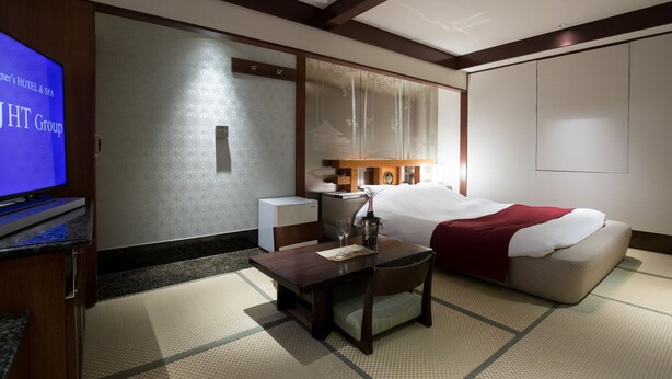 A hotel room with a bed, bedside table, TV, and a small desk with a chair. - HOTEL PERRIER - Adults Only (Tokyo)