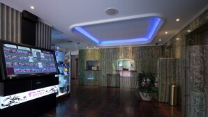 A hotel reception area with a digital display, marble walls, and a modern ceiling design. - HOTEL PERRIER - Adults Only (Tokyo)