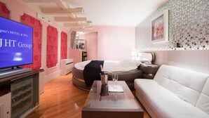 A modern hotel room with a bed, a white sofa, a TV, and a minibar. - HOTEL PERRIER - Adults Only (Tokyo)