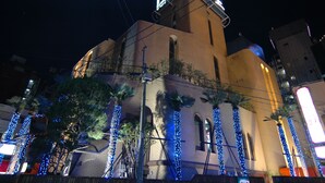 A building with a prominent sign, brick walls, and blue decorative lights. - HOTEL PERRIER - Adults Only (Tokyo)