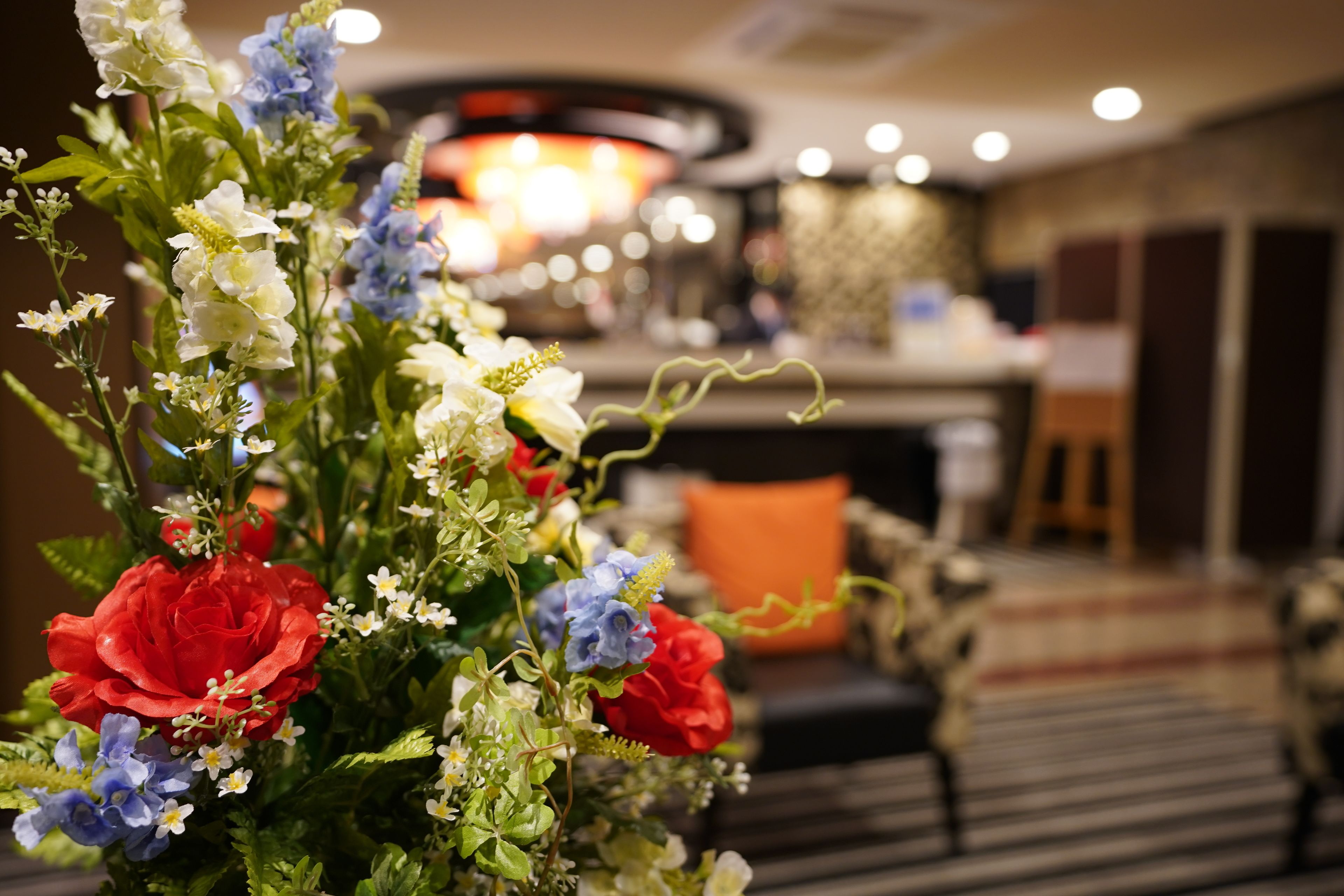 A floral arrangement with red and blue flowers in a hotel lobby.