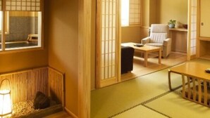 Une pièce de style japonais traditionnel, avec un sol recouvert de tatamis, une petite table basse, une chaise et une porte coulissante donnant sur une autre pièce.