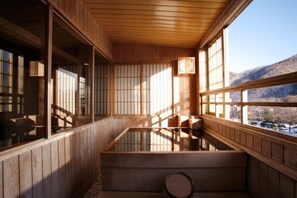 Un onsen japonais traditionnel, avec un décor intérieur en bois et une vue sur les montagnes.