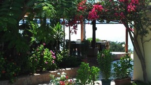 A garden with potted plants and a table. - Fournia Village (Andravida-Kyllini)