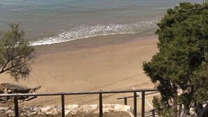 A beach with clear water, a distant mountain, and sparse vegetation. - Fournia Village (Andravida-Kyllini)