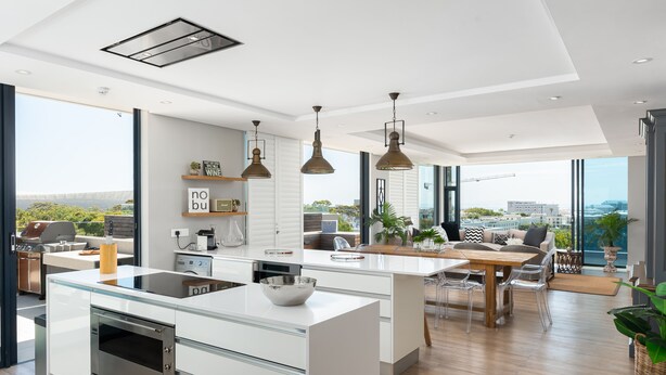 A modern kitchen with a central island, large windows, and a view of the city. - Warwick 504 (Cape Town)