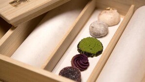 A wooden box with compartments containing various food items.