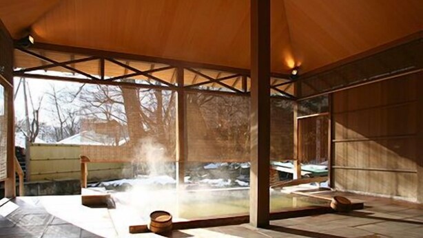 A spacious room with a high ceiling and large windows, providing a view of the outdoors. - Kuriyasuizan (Sapporo)