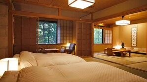 Ein traditioneller japanischer Raum mit Tatami-Böden, einem Bett, einem Schreibtisch und einem Stuhl.