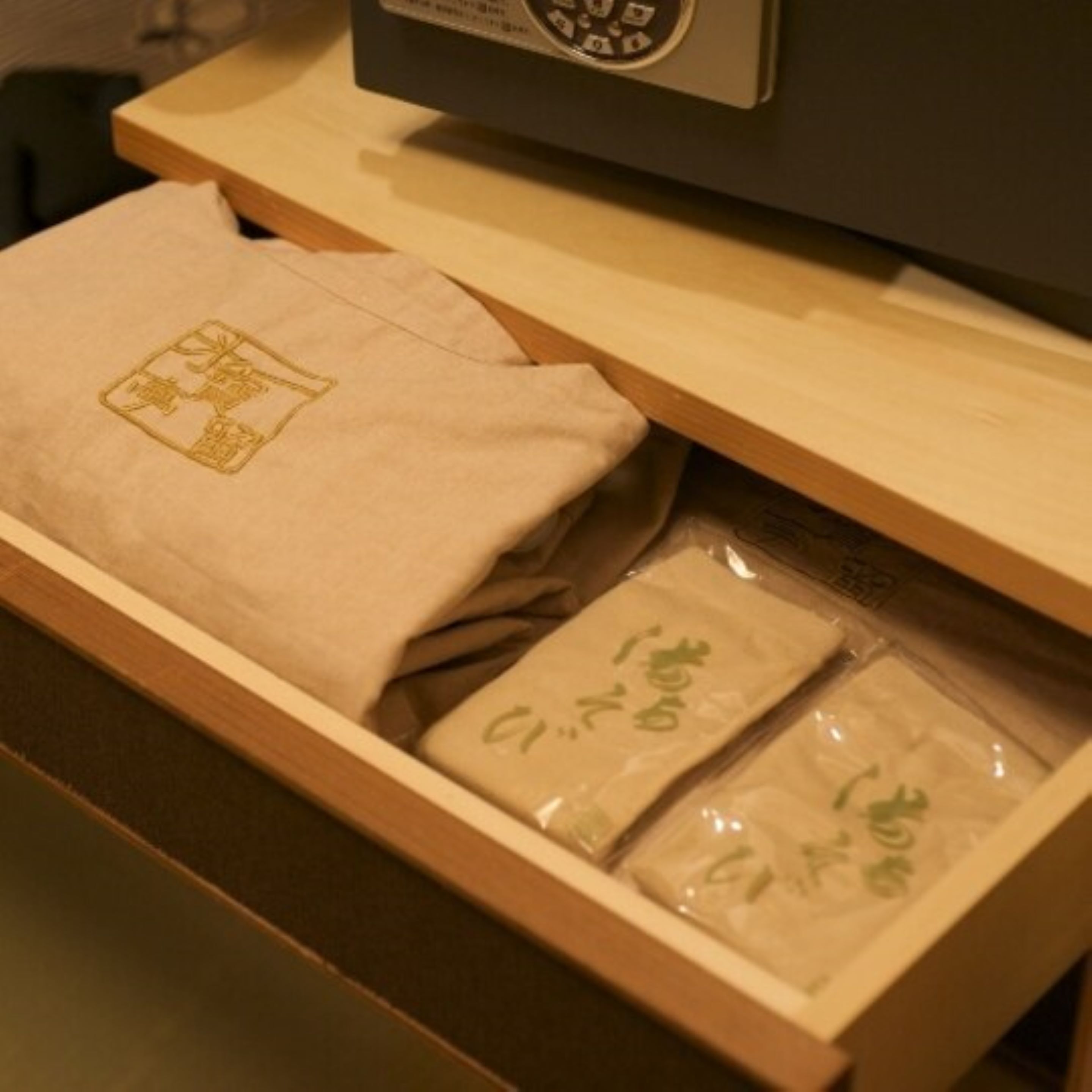 A drawer with a beige towel and two packages with green text.