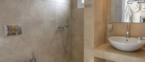 A modern bathroom with a toilet, shower, and sink.
