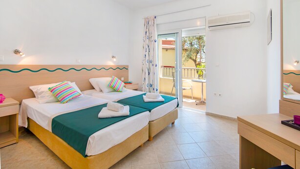 A hotel room with two beds, a balcony, and an air conditioning unit. - Hidden garden Rhodes Apartments (Rhodes)