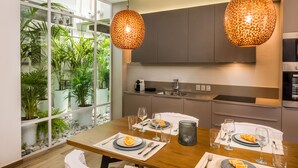 A modern kitchen with a dining area, large windows, and potted plants. - No17 Pireos Street (Chania)