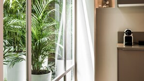 A modern kitchen with a large window, a built-in plant wall, and a minimalist design. - No17 Pireos Street (Chania)