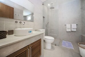 A modern bathroom with a sink, toilet, and shower.