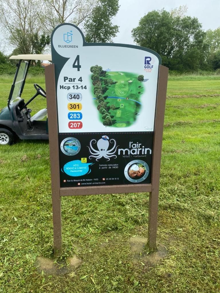 A golf course sign with a map, hole numbers, and distances.