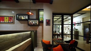A cozy dining area with a wooden bench and wicker chairs, a table with a vase, and a view into a kitchen and dining room. - Manor Le Rayon Vert (Ji'an)