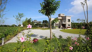 A modern building with a gravel driveway and lush greenery. - Manor Le Rayon Vert (Ji'an)