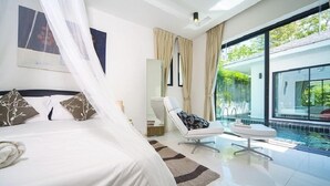 Une chambre moderne dotée d’un grand lit, d’un coin salon et offrant une vue sur une piscine.