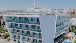 Ein modernes Hotel mit mehreren Etagen, einem Pool auf dem Dach und Solaranlagen.