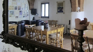 Comedor con techo de ladrillo, mobiliario de madera y un espejo grande que refleja la habitación.