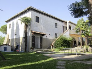 A two-story building with a white facade, a tiled roof, and a small porch area. - Albergo Montechiari (Palaia)