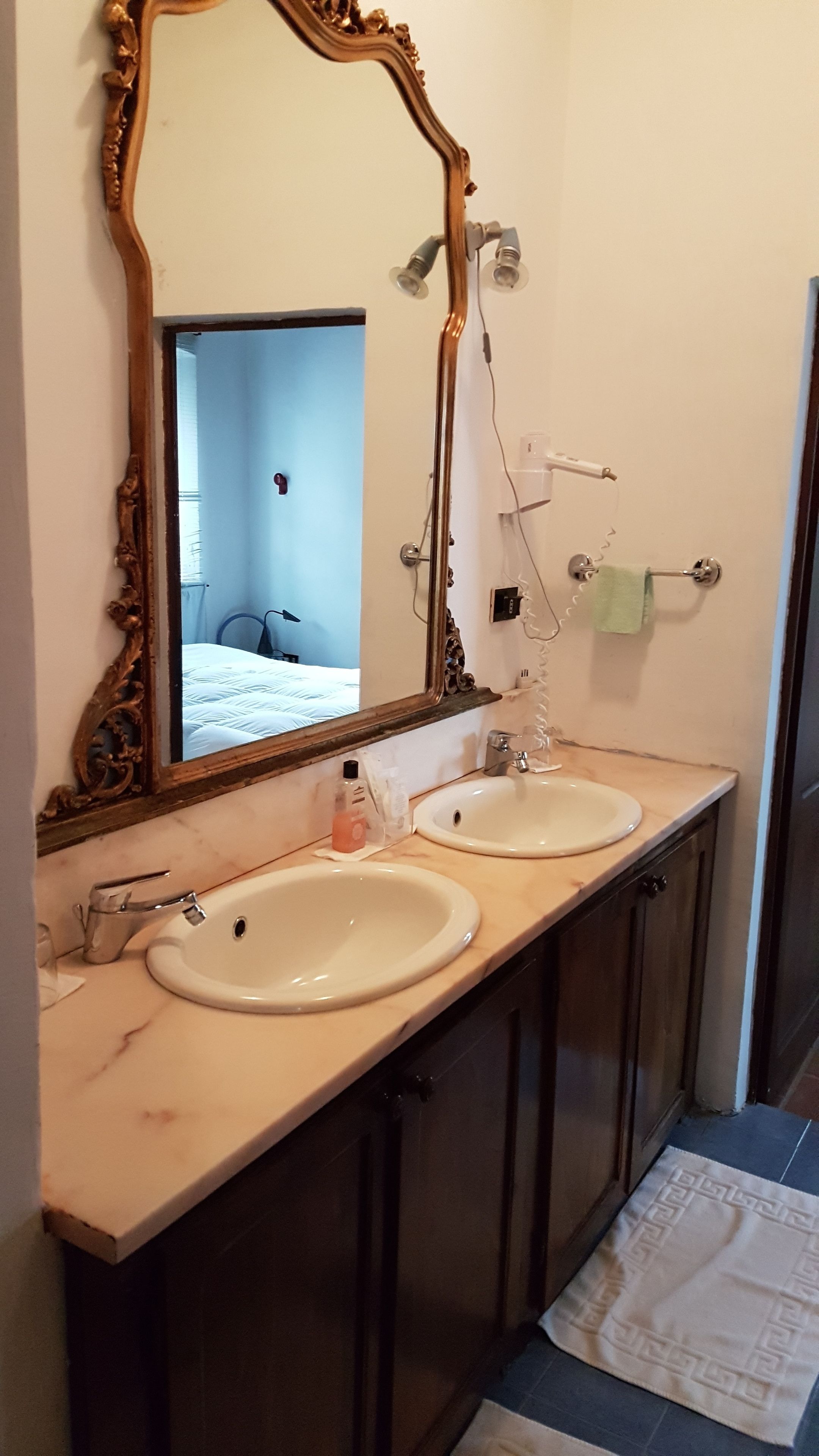 Ein Badezimmer mit zwei Waschbecken, einem großen Spiegel und einem Handtuchhalter.