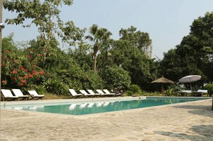 Una piscina al aire libre, camas de piscina gratis, sombrillas