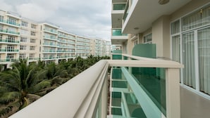 Een modern hotel met meerdere verdiepingen, balkons en een palmentuin.